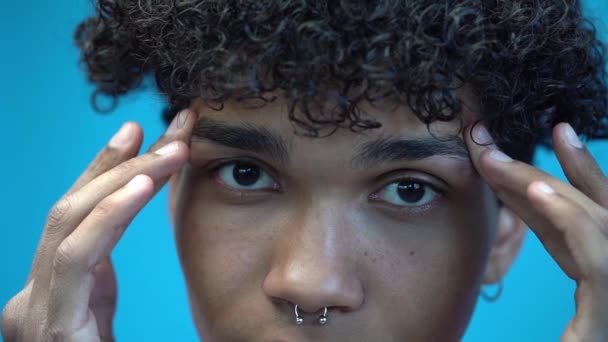 slow-motion van Afro-Amerikaanse man styling wenkbrauwen geïsoleerd op blauw - Video
