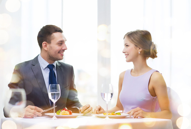 Smiling couple eating main course at restaurant - Photo, Image
