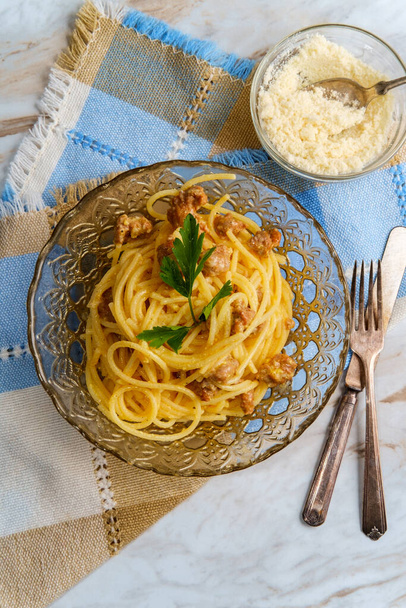кремовая итальянская кухня спагетти alla carbonara с крошечной колбасой и гарниром из петрушки - Фото, изображение