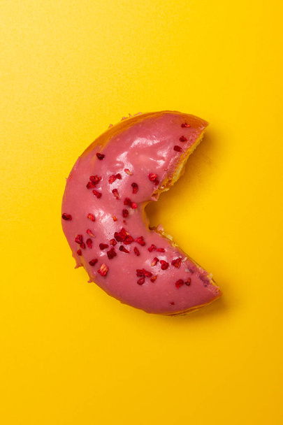 donut met frambozen en roomkaas op een gele achtergrond - Foto, afbeelding