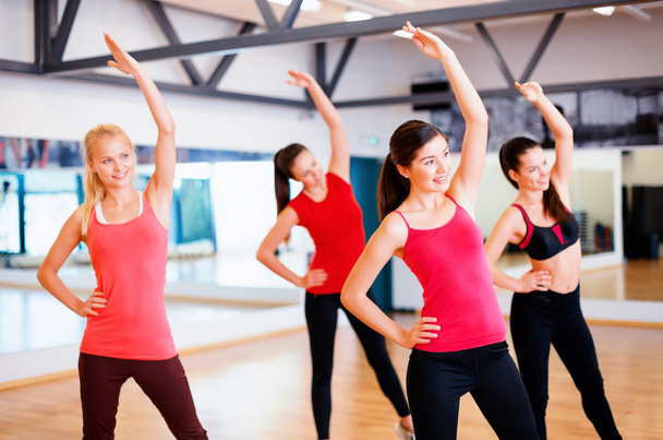 Group of smiling people stretching in the gym - Foto, immagini