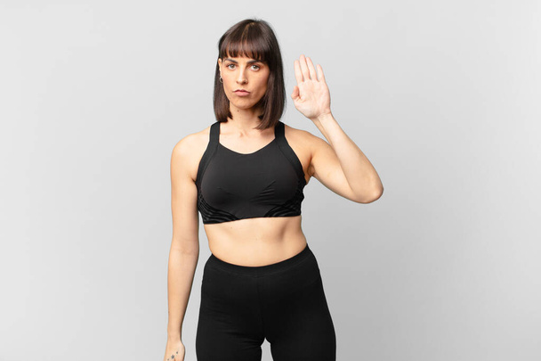 athlete woman looking serious, stern, displeased and angry showing open palm making stop gesture - Φωτογραφία, εικόνα