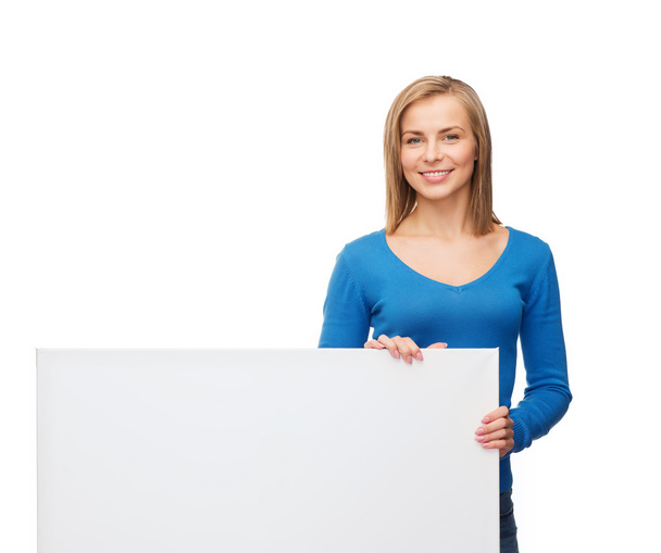 Smiling woman in sweater with blank white board - Foto, afbeelding