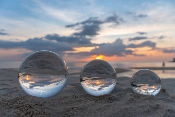 Три прозрачных хрустальных шара трех размеров являются сфера показывает вид на море со сферической - Фото, изображение