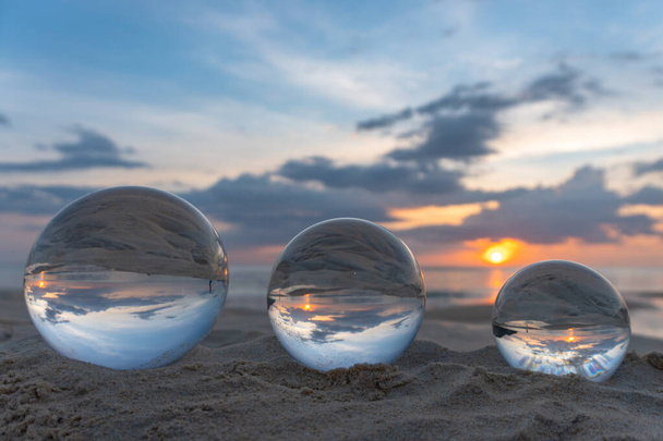 Три чіткі кристалічні кульки трьох розмірів сфера відкриває вид на морський пейзаж з сферичним
 - Фото, зображення