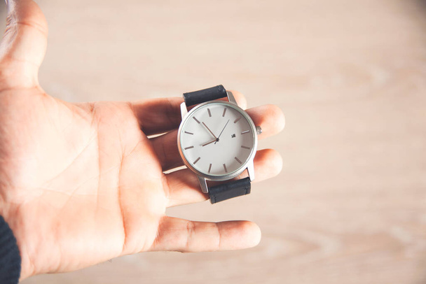 ruční drží hodiny izolované na dřevěném pozadí - Fotografie, Obrázek