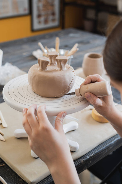 Dítě v procesu zdobení hliněné vázy. Dětské keramické studio. - Fotografie, Obrázek