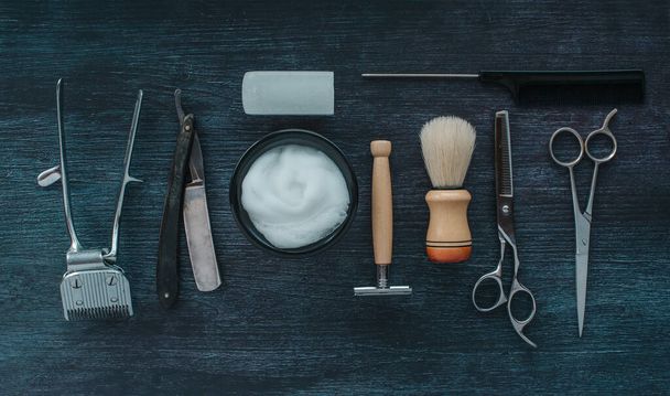 Vue du dessus Outils de salon de coiffure vintage. Rasoir, ciseaux, brosse, rasoir, alun sur fond bois foncé, Outils anciens - Photo, image