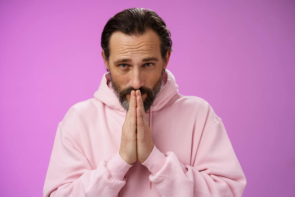 Worried intense serious-looking troubled handsome mature bearded man praying waiting important news nervously looking camera press palms supplicating wish wife alright, standing purple background - Photo, Image