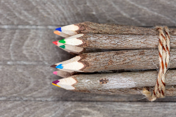 crayons reliés en bois véritable non traité sur la vue du dessus avec écorce d'arbre véritable sur une planche en bois marron pour les artistes, les étudiants et les amoureux de la nature. Horizontal - Photo, image