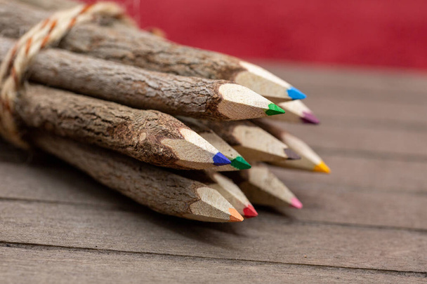 привязанные карандаши из настоящего, необработанного дерева, уникальные и с настоящей корой дерева на деревянной доске для студентов, художников и любителей природы. Горизонталь - Фото, изображение