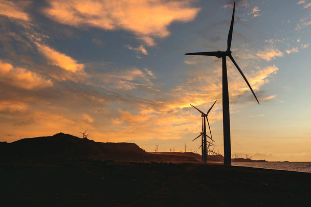 Ветряная электростанция вдоль береговой линии во второй половине дня в Банги, Илокос-Норте, Филиппины. Устойчивая и возобновляемая энергетика в Азии. - Фото, изображение