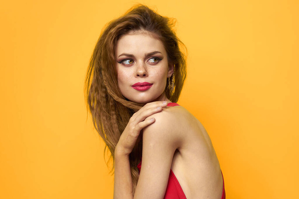 Pretty woman wavy hair red tank top fashion lifestyle cosmetics yellow background - Fotografie, Obrázek