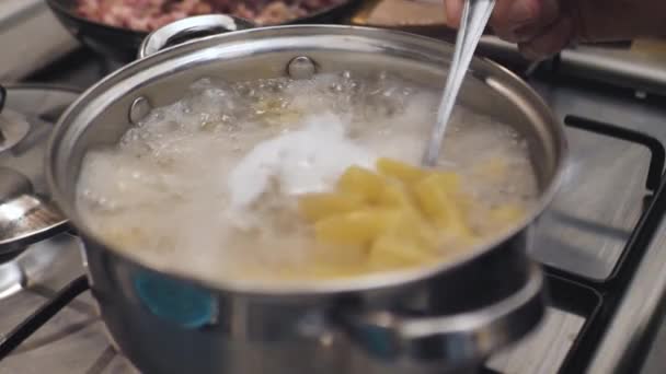 koken, restaurant, keuken, koken, huisvrouw concept - close-up uitzicht op witte pasta gekookte gekookte bonen op pan op fornuis. Potje met diner in de keuken - Video