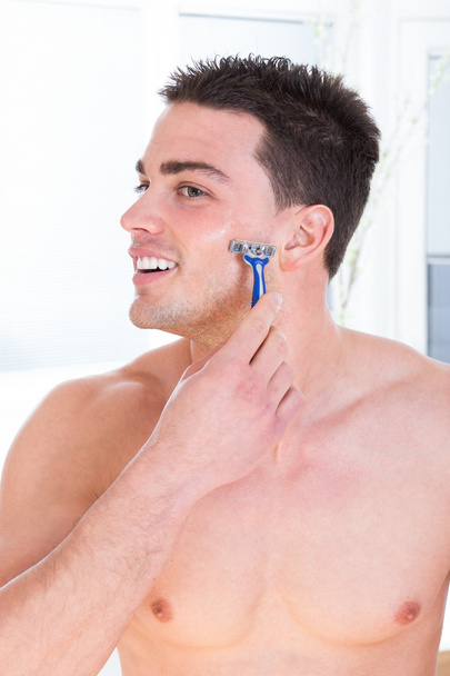 attraktiver Mann rasiert sein Gesicht mit Rasiermesser - Foto, Bild