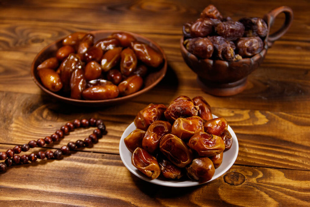 Datuje owoce i różaniec na drewnianym stole. Muzułmańskie święto świętego miesiąca Ramadan - Zdjęcie, obraz