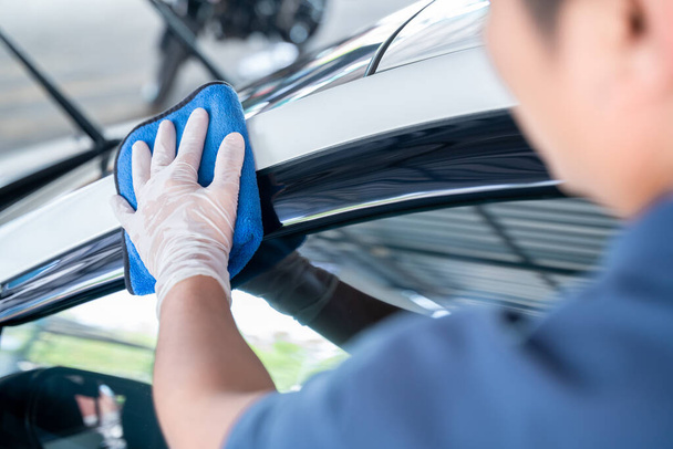 Mão de perto do homem segura a microfibra na mão e polir o carro, conceito de serviço de lavagem de carro. - Foto, Imagem
