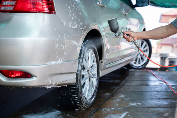 Auto wassen in de wasstraat om vuil op te ruimen en de gezondheid van de bestuurder en passagiers te behouden, Car wash service concept. - Foto, afbeelding