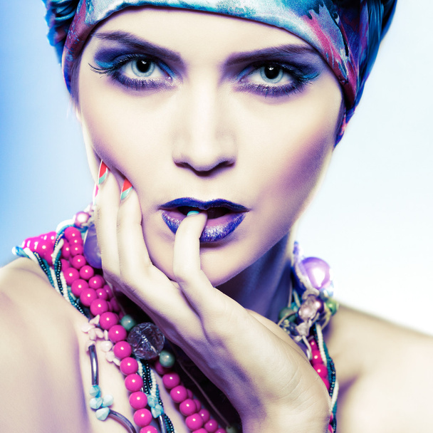 A photo of beautiful  girl in a head-dress from the coloured fabric,on a blue background,  glamour - 写真・画像