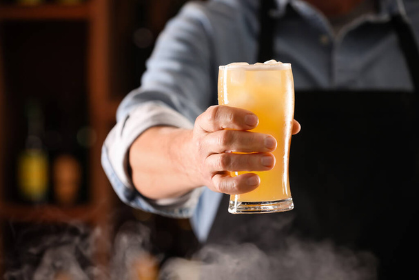 Μπάρμαν με ποτήρι φρέσκιας μπύρας τζίντζερ στο μπαρ - Φωτογραφία, εικόνα
