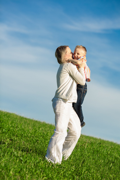 Beautiful boy and mom playing in spring park. Happy family concept. - 写真・画像