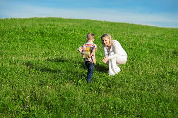 Beautiful boy and mom in spring with present. Mothers day or birthday celebration concept - Photo, Image