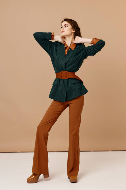 サイドファッションライフスタイルを追求するスーツ姿の可愛い女性ベージュの背景 - 写真・画像