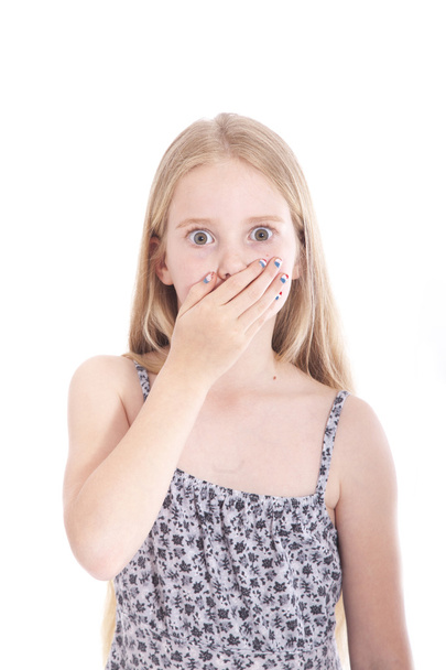 junges blondes Mädchen mit der Hand auf dem Mund im Studio - Foto, Bild