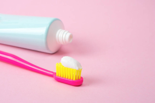 Dental toothpaste and toothbrush isolated on pink background. Dental hygiene and health concept - Photo, Image