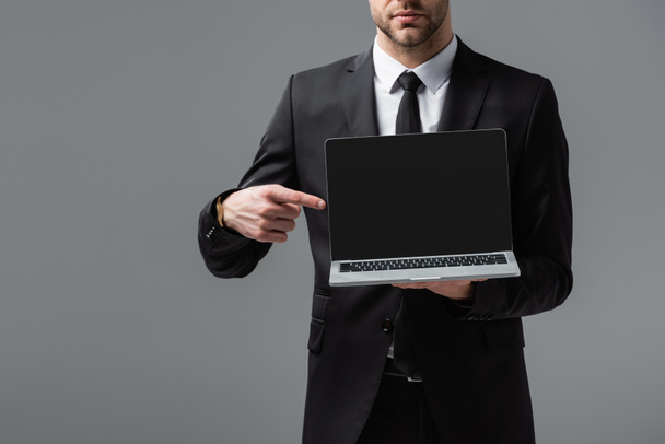 Ausgeschnittene Ansicht des Managers in formaler Abnutzung zeigt auf Laptop mit leerem Bildschirm isoliert auf grau - Foto, Bild