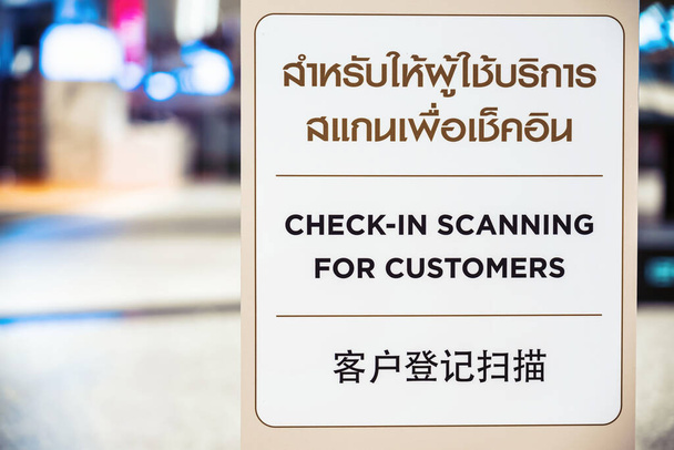Covid-19 πανδημία, νέα κανονική Concept, Check-in Σάρωση για κείμενο πελατών με ταϊλανδέζικη και κινεζική γλώσσα στο Billboard πριν από το περπάτημα στο πολυκατάστημα - Φωτογραφία, εικόνα