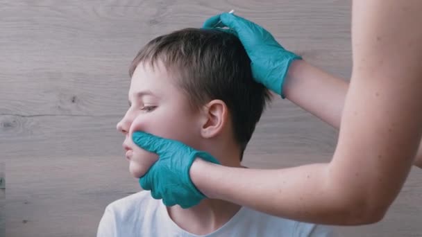 El doctor otorrinolaringólogo limpia las orejas, canal del oído de un niño con un hisopo de algodón. 4K - Imágenes, Vídeo