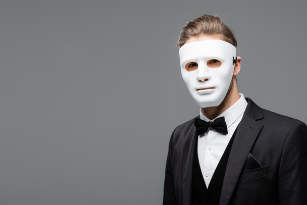 young businessman in face mask looking at camera isolated on grey - Photo, Image