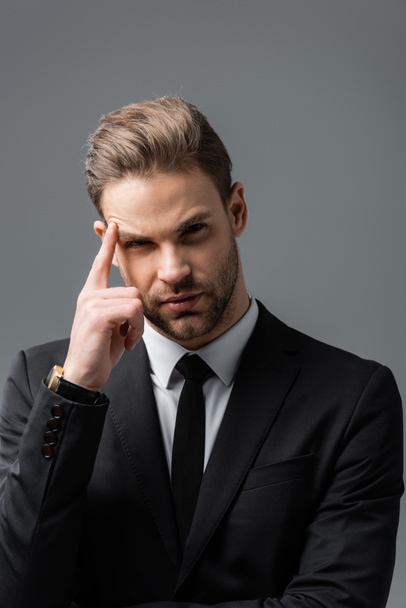 thinking businessman touching head and looking at camera isolated on grey - Photo, Image