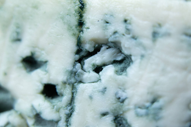 голубой сыр с голубой плесенью в качестве фоновой макрофотографии, сыр с благородной голубой плесенью - Фото, изображение