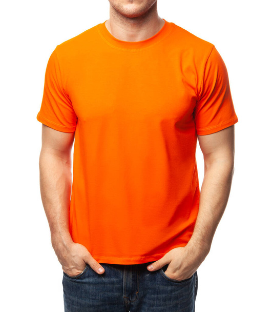 Νεαρός γυμνασμένος άντρας με λευκό πορτοκαλί κοντομάνικο βαμβακερό μπλουζάκι. Αποτύπωση προτύπου που απομονώνεται σε λευκό φόντο - Φωτογραφία, εικόνα