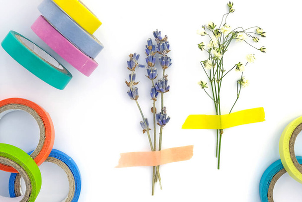 Set of paper sticky tape on a white background. Colored self-adhesive tape for decoration. Decorative adhesive tape for hobby. Small bouquet of dry lavender and gypsophila glued to paper, herbarium  - Photo, Image