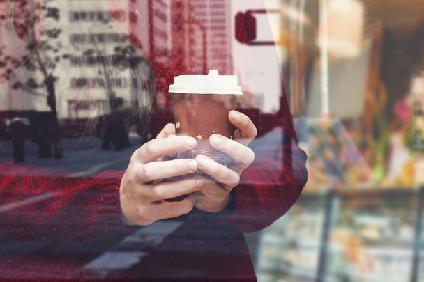 detailní záběr žena drží jednorázové šálek kávy v blízkosti okna kavárny - Fotografie, Obrázek