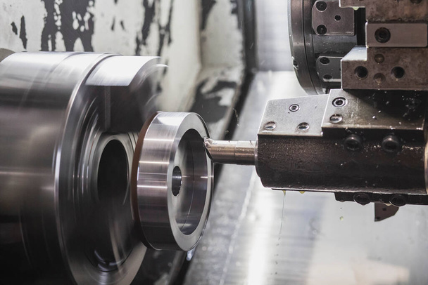 Un fresador en una máquina CNC corta una pieza de metal que gira a alta velocidad - Foto, Imagen
