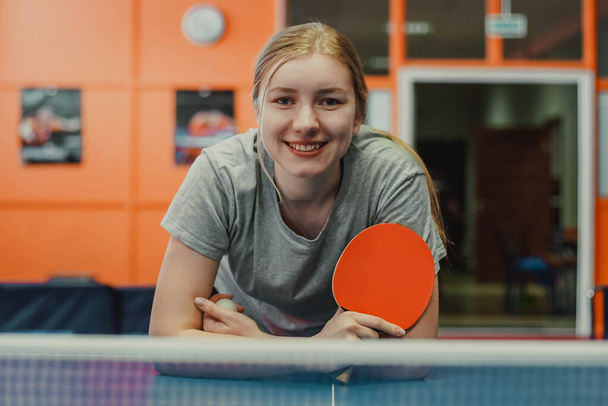 Portrét usměvavé dospívající dívky stolní tenista s ping pong raketa - Fotografie, Obrázek