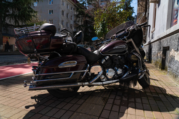 Piros motorkerékpár koponyákkal az utcán - Fotó, kép