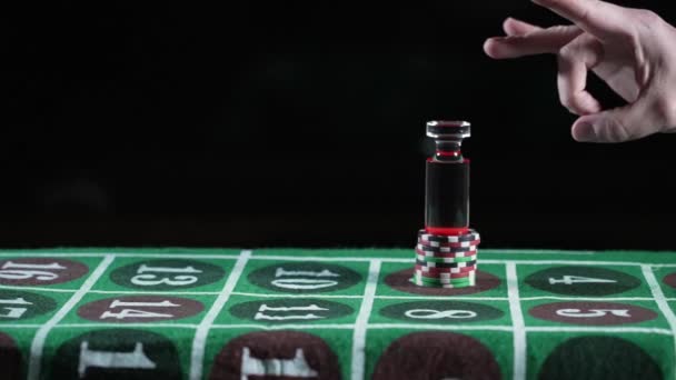 Een roulette dealer gooit een roulette marker weg bovenop een stapel gaming chips. Neergeschoten op 240 fps. Chips zijn generiek en vertegenwoordigen geen bepaald casino.   - Video