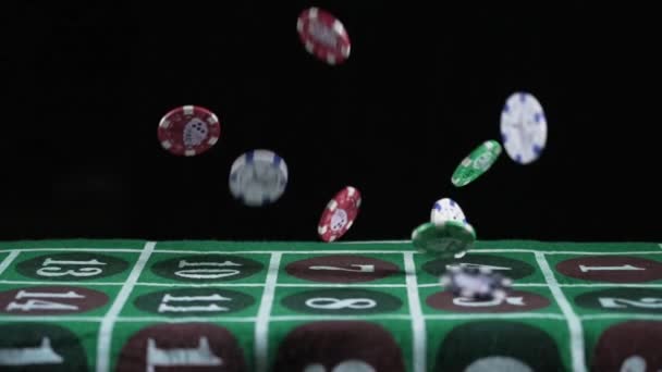 Casino gaming chips vallen op een roulette tafel in slow motion. Neergeschoten op 240 fps. Chips zijn generiek en vertegenwoordigen geen bepaald casino.   - Video