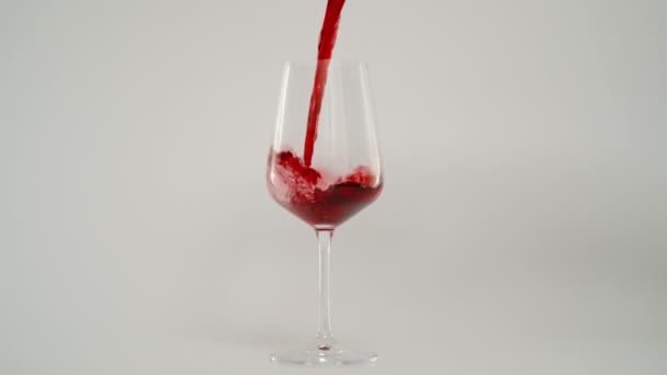 Наливаючи червоне вино в склянку зі швидкістю 1000 фунтів стерлінгів, супер повільний постріл, білий фон
  - Кадри, відео