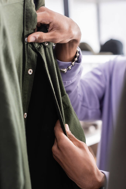 Vista cortada do proprietário americano africano da camisa tocante do showroom no primeiro plano borrado  - Foto, Imagem