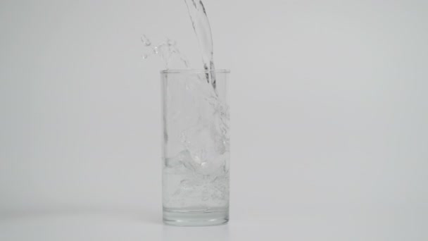 Zeitlupe des Gießens von Wasser in transparentem Glas mit Eis, 1000 fps  - Filmmaterial, Video