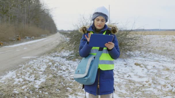 道路の近くに落ちた枝を検査する女性技術者 - 映像、動画