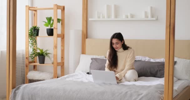Mujer riendo mientras usa el portátil en la cama - Metraje, vídeo