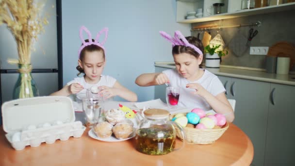 Little girls wearing bunny ears painting eggs on Easter day - Footage, Video