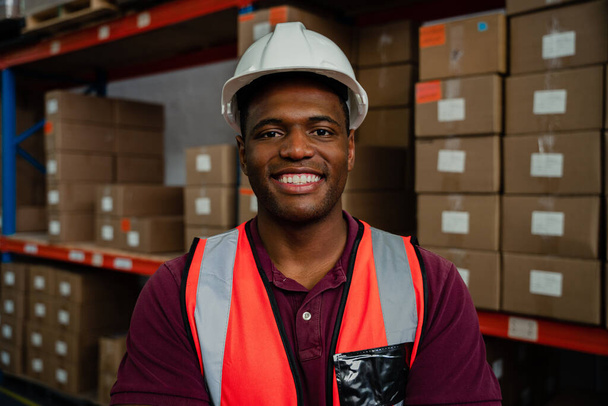 Close up portrait of male worker smiling wearing hardhat in warehouse  - Фото, изображение